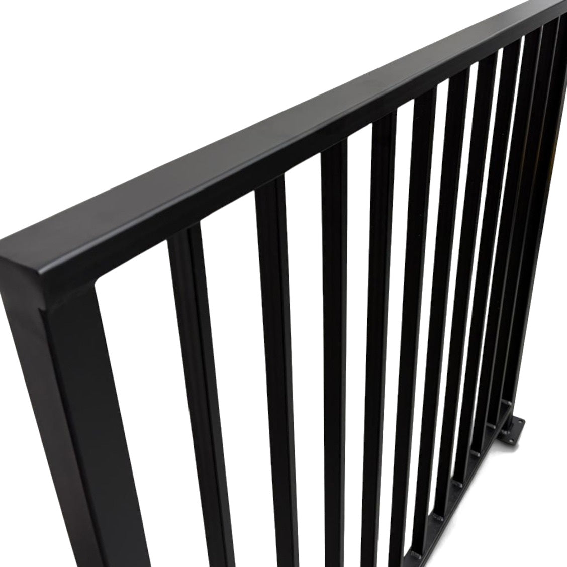 Close view of the Axis railing cap rail corner and welded vertical bars in matte black powder coated steel