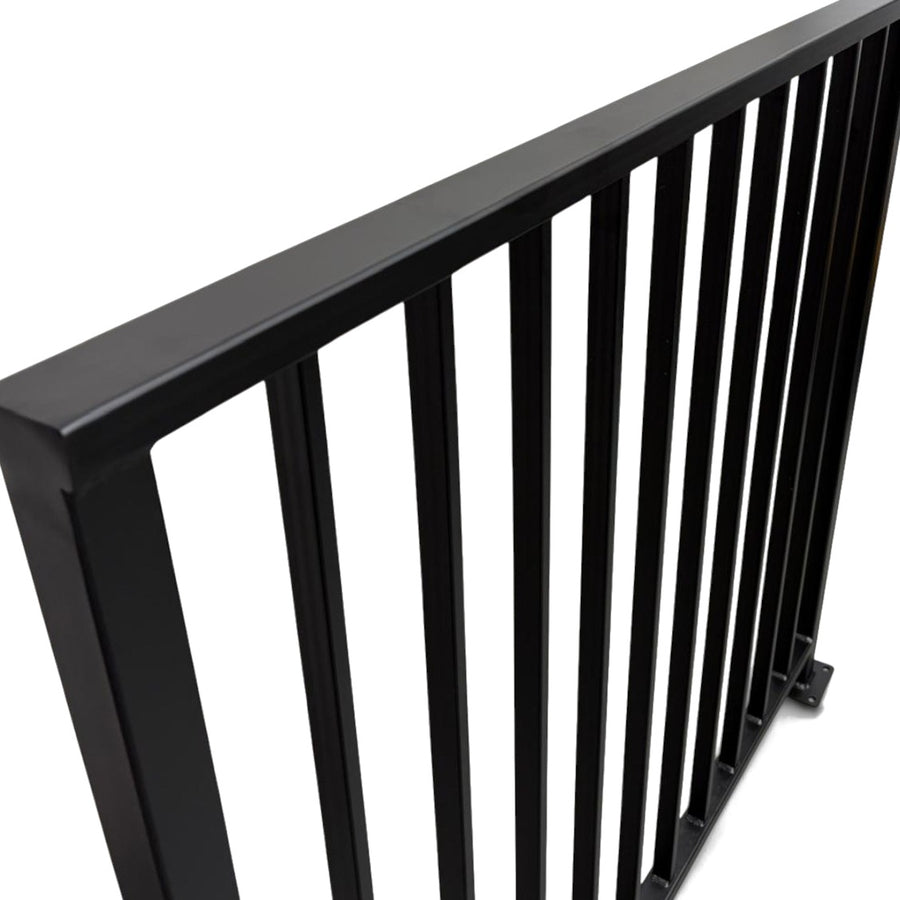 Close view of the Axis railing cap rail corner and welded vertical bars in matte black powder coated steel