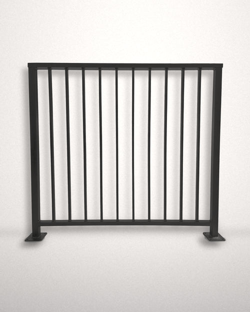 Axis vertical bar railing panel in matte black powder coated steel standing against a plain wall — custom welded guardrail with flat top cap rail and bolt-down base plates, made to size in New Jersey