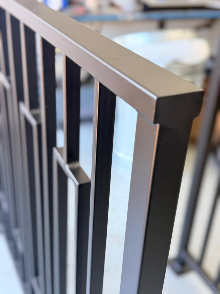 Detail of a Keystone framed railing showing the frame offset and welded joints in matte black powder coated steel
