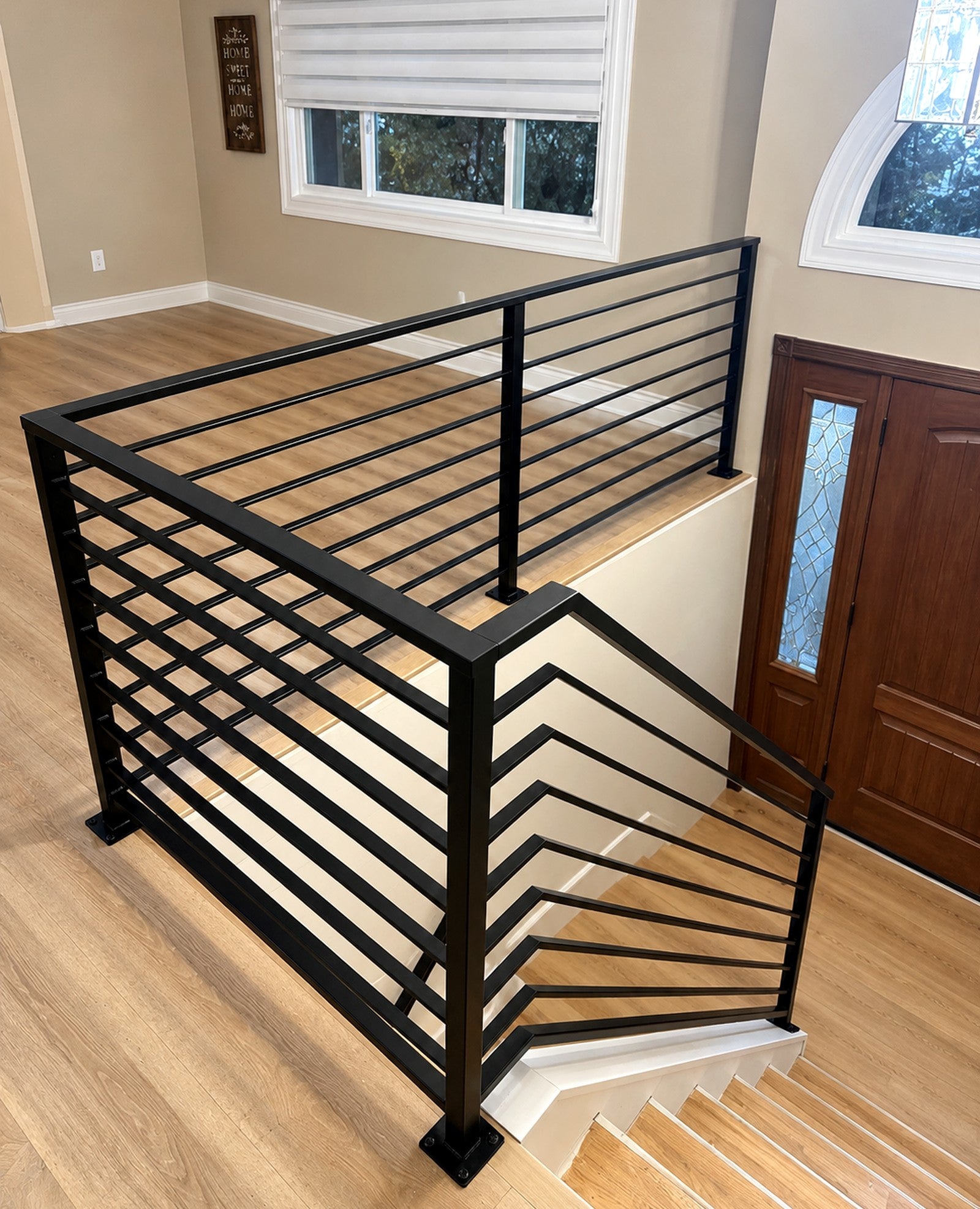Black metal stair railing with horizontal bars, installed in a New Jersey home